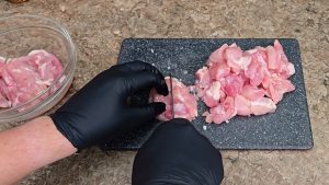 Cutting chicken thighs into 3cm chunks ready to marinade
